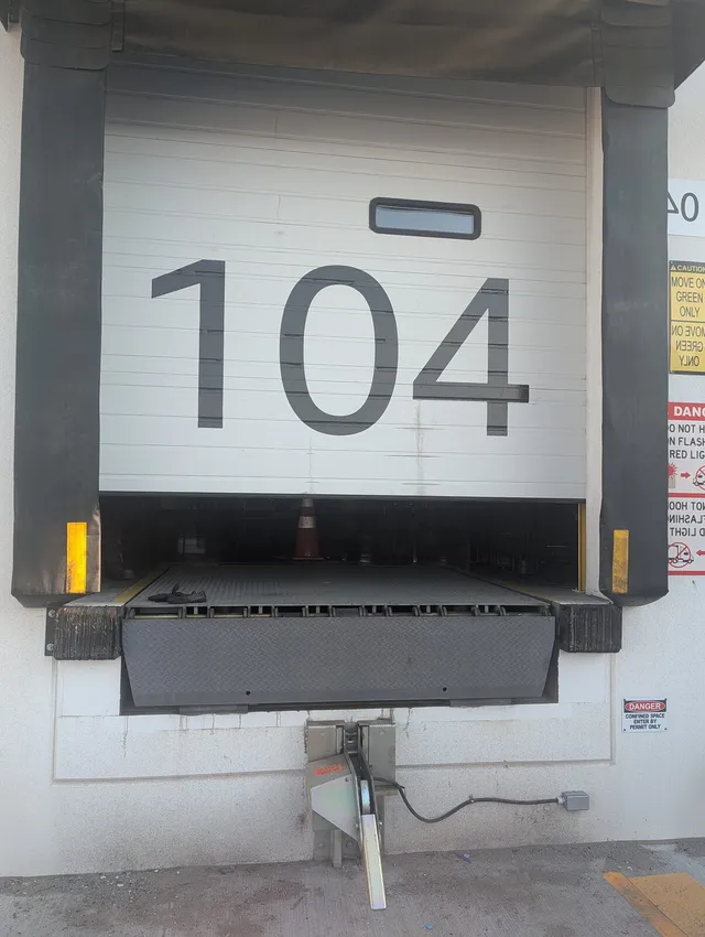 Dock leveler and door restraint at a commercial loading dock